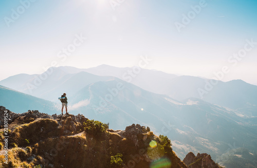 Mountain hiker with backpack tiny figurine stay on mountain peak with beautiful panorama