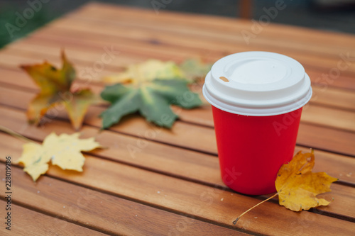 Coffee to go on a table of a street cafe in the autumn