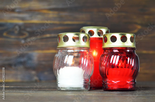 Votive grave candle memorial lanterns on wooden background