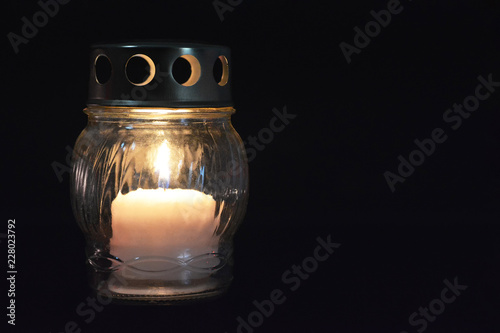 White votive candle lantern on dark background photo