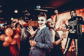 Young Smiling Couple in Halloween Costumes Dancing