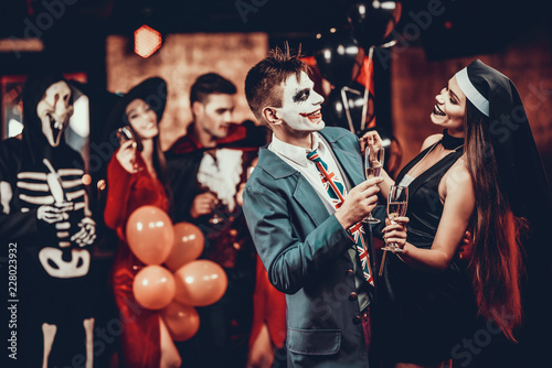 Young Smiling Couple in Halloween Costumes Dancing