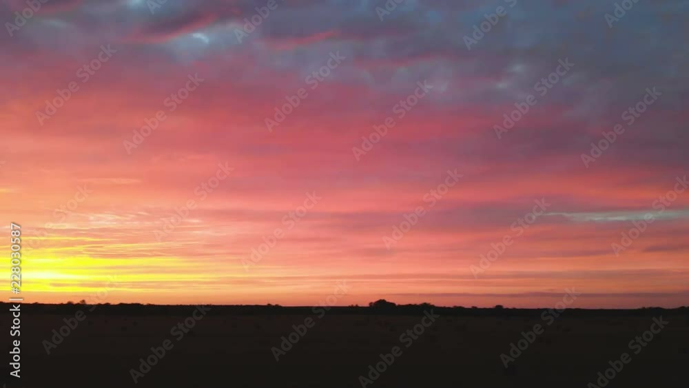 Golden multicolor sunset over a farm field with hay bales. Flying drone over a mowed wheat field at dusk. Low key 4k Golden multicolor sunset over a farm field with hay bales. Flying drone over a mowed wheat field at dusk. Low key 4k