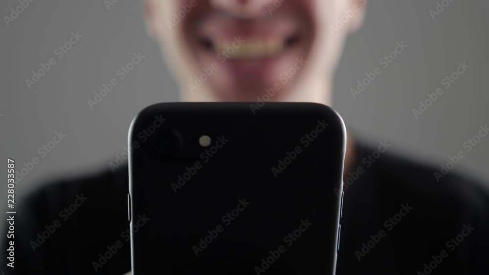 Closeup of Happy Young Man Using Smartphone, Browsing in Internet or Checking Social Networks on white background