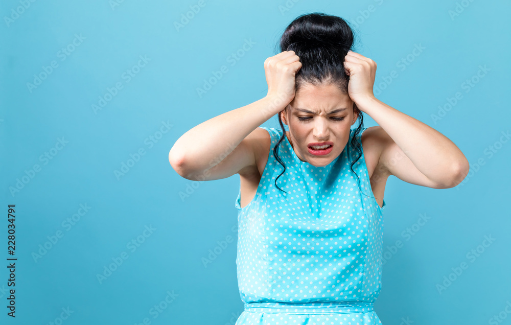 Young woman feeling stressed on a solid background Young woman feeling stressed on a solid background