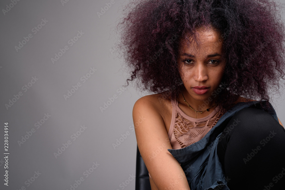 Young beautiful African woman against gray background Young beautiful African woman against gray background