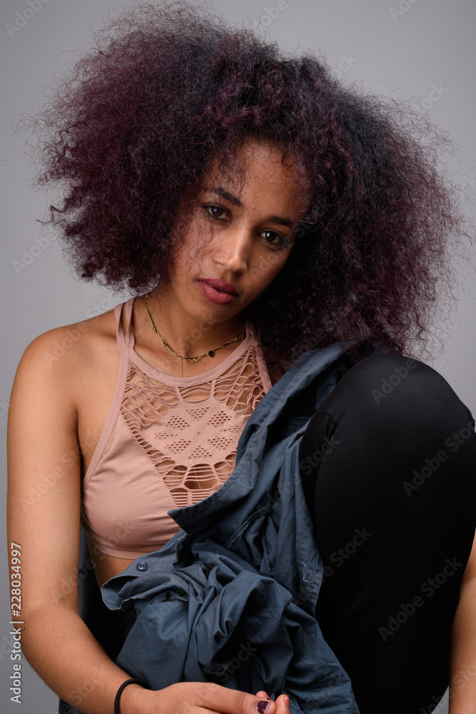 Young beautiful African woman against gray background Young beautiful African woman against gray background