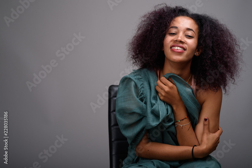 Young beautiful African woman against gray background photo