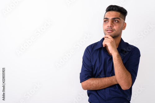 Studio shot of young Indian businessman against white background
