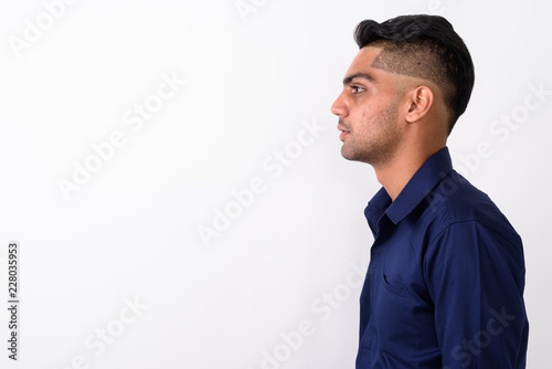 Studio shot of young Indian businessman against white background