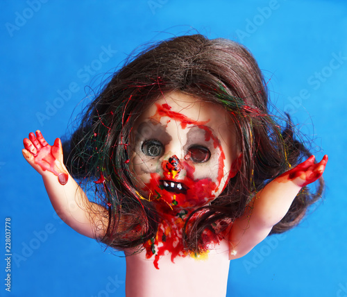 A generic China child doll is made up for a zombie like frightening appearance, showing blood and gore dripping from the mouth.