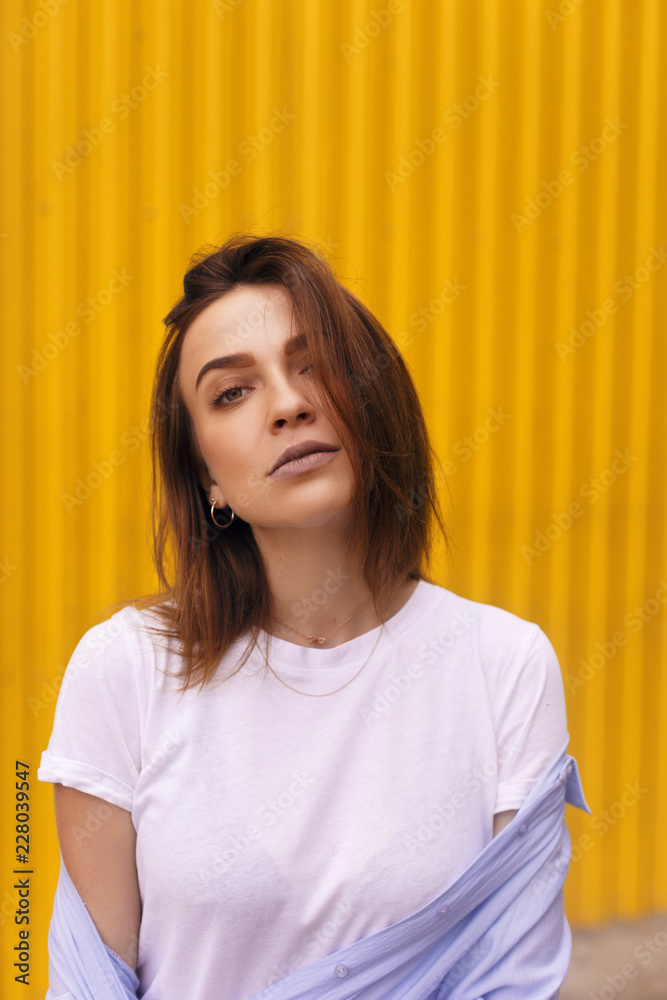 Portrait attractive woman on yellow background. she look on camera pretentious or arrogantly. Brunette girl with short hair. Portrait attractive woman on yellow background. she look on camera pretentious or arrogantly. Brunette girl with short hair.