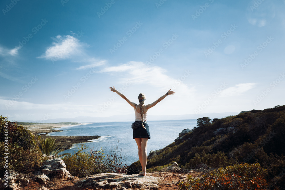 Girl at the edge of the cliff overlooking the sea Girl at the edge of the cliff overlooking the sea