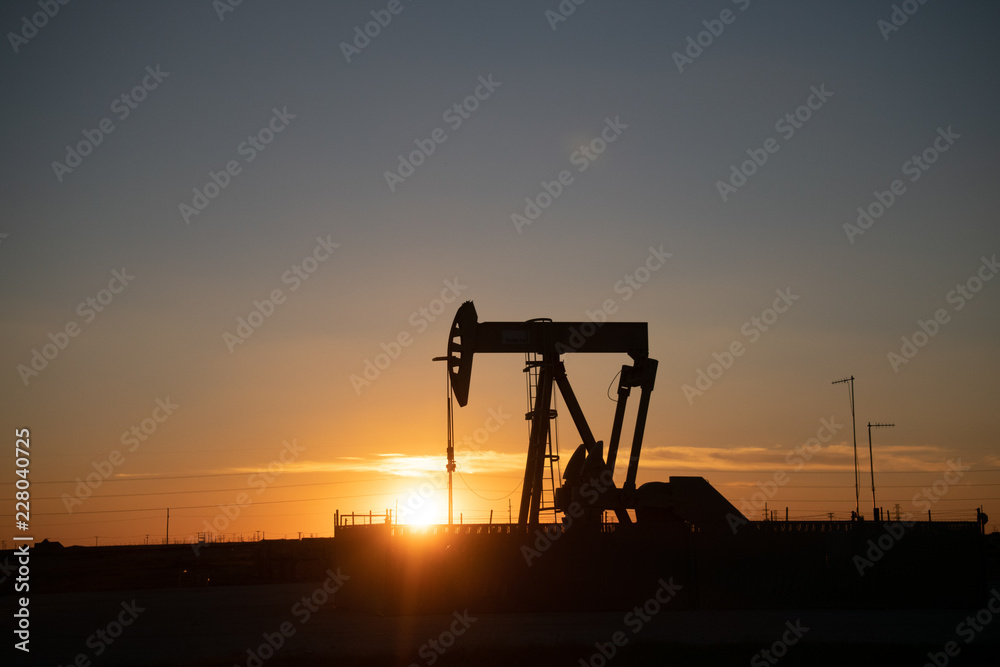 silhouette of oil pump in sunset