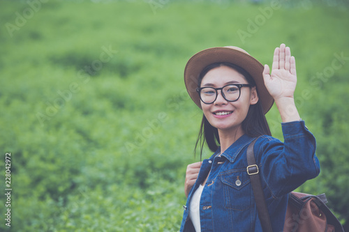Woman traveler with backpack hat and looking at lies on a meadow in the mountains.