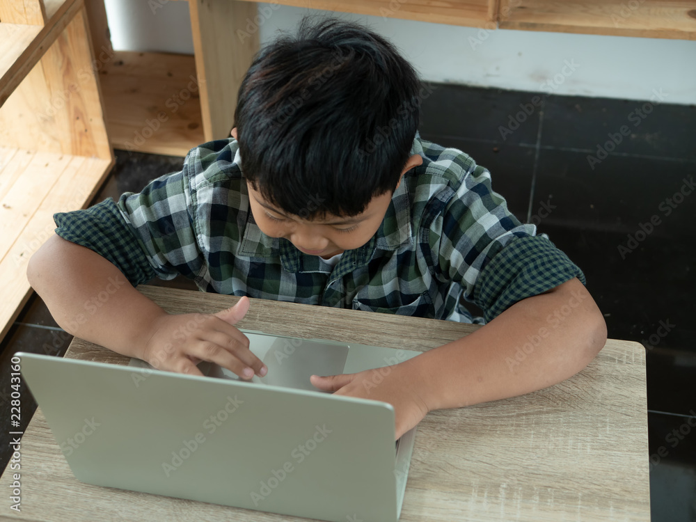 Cute asian children using a laptop computer on desk in the room. Education and Technology concept. Cute asian children using a laptop computer on desk in the room. Education and Technology concept.