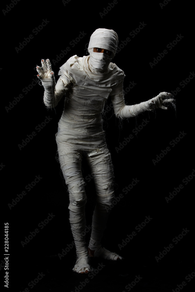 Studio shot portrait  of young man in costume  dressed as a halloween  cosplay of scary mummy pose like a clamber acting on isolated black background.