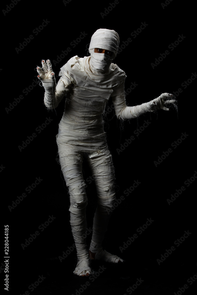 Studio shot portrait of young man in costume dressed as a halloween cosplay of scary mummy pose like a clamber acting on isolated black background. Studio shot portrait of young man in costume dressed as a halloween cosplay of scary mummy pose like a clamber acting on isolated black background.