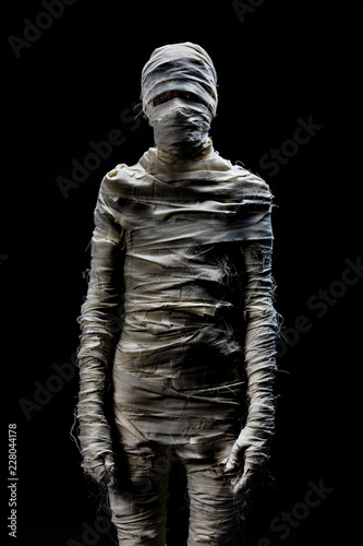 Obraz na plátně Someone in peices of cloths as mummy cosplay on black background