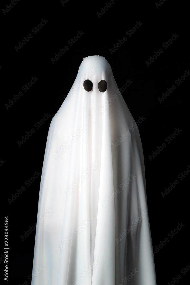 Someone covered with white cloth with big black eyes on black background look like ghost in night. Concept for funny playing in halloween festival