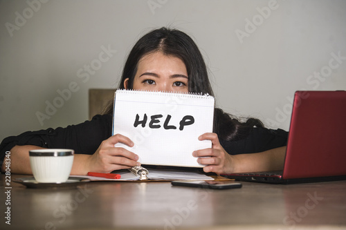 young stressed and depressed Asian Chinese businesswoman working overwhelmed and exhausted as corporate business employee asking for help desperate photo