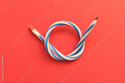 Flexible pencil . Isolated red background