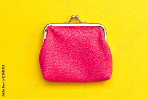Pink wallet on yellow background . Close up. Top view