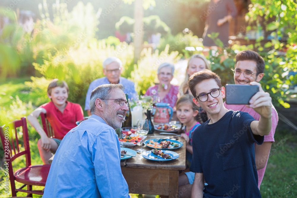 Obraz premium during a bbq a boy does a selfie with the whole family
