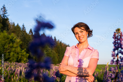 Beautiful girl in a field of purple lupines