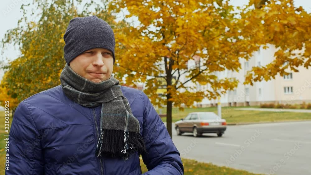 ill or sick man takes a pill or tablet against sore throat due to Influenza flu virus in the city or outdoor in the fall or autumn ill or sick man takes a pill or tablet against sore throat due to Influenza flu virus in the city or outdoor in the fall or autumn