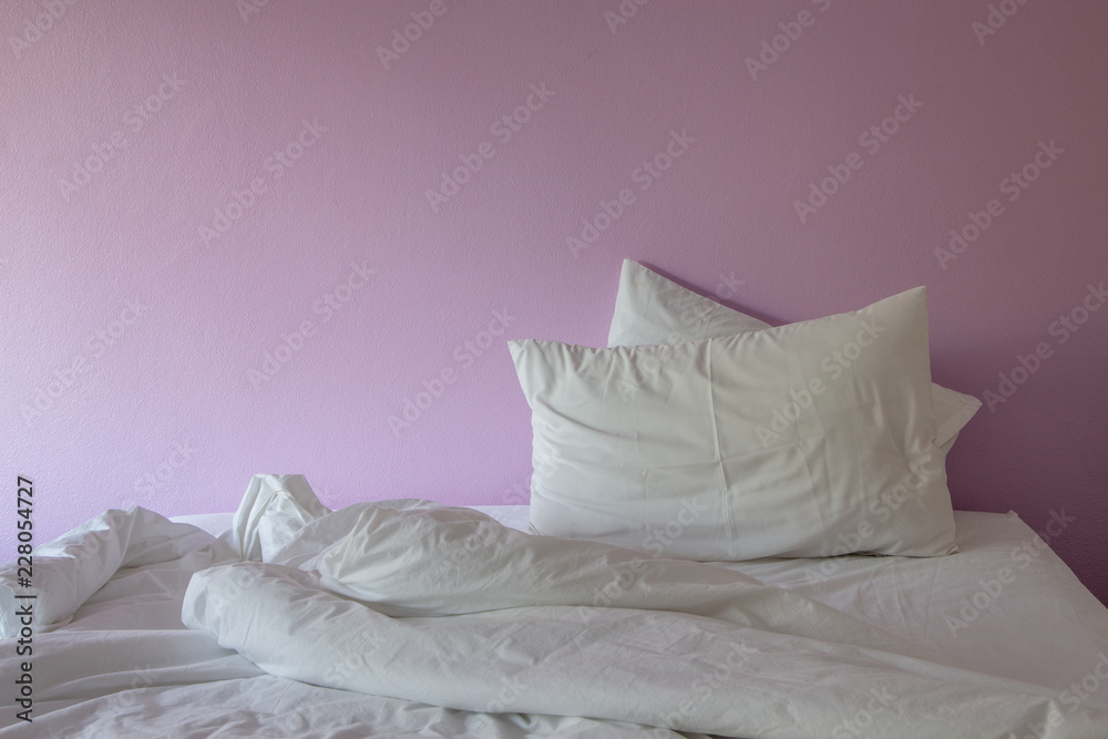Obraz premium white wrinkle messy blanket and pillow on pink background.