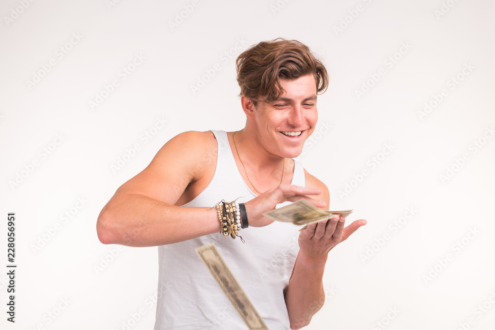 Rich, fun and finance concept - handsome young man throws money over white background. Rich, fun and finance concept - handsome young man throws money over white background.