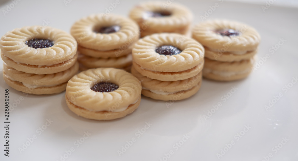TART SANDWICH COOKIES WITH CREAM & STRAWBERRY FLAVORED JAM. selective focus. light leak effect TART SANDWICH COOKIES WITH CREAM & STRAWBERRY FLAVORED JAM. selective focus. light leak effect