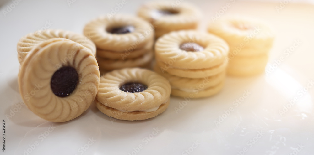 TART SANDWICH COOKIES WITH CREAM & STRAWBERRY FLAVORED JAM. selective focus. light leak effect TART SANDWICH COOKIES WITH CREAM & STRAWBERRY FLAVORED JAM. selective focus. light leak effect