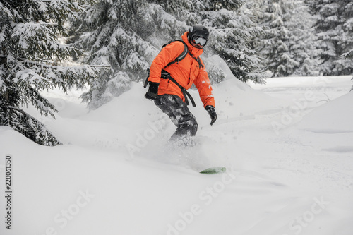 Man riding down the hill between snowcovered trees