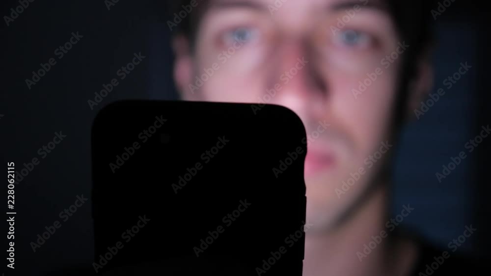 Closeup of Young Man Using Smartphone at Night, Browsing in Internet or Checking Social Networks
