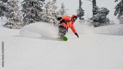 Man running down the mountain hill on the snowboard