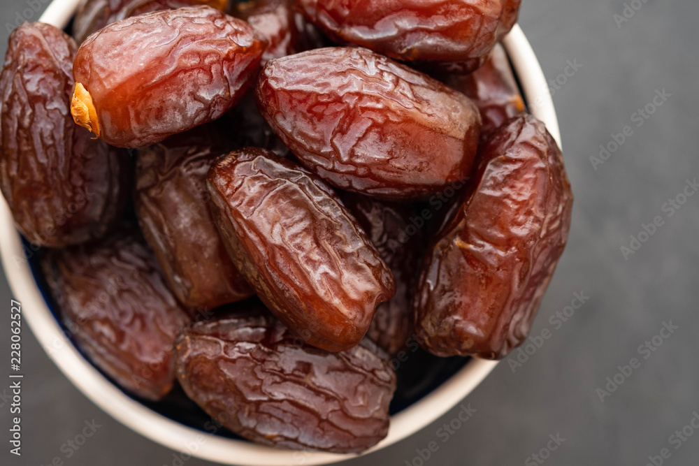 Fresh Medjool Dates in a bowl. Ramadan kareem. Black background. Top view. Copy space. Fresh Medjool Dates in a bowl. Ramadan kareem. Black background. Top view. Copy space.