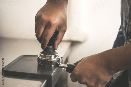 Barista using tamping for freshly roasted coffee bean make into a powder.