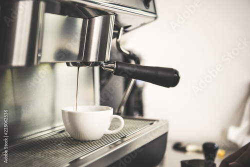 Billede på lærred Barista using coffeemaker extraction for espresso shot in cafe.