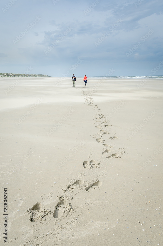 Foodsteps on the beach of Terschelling 2 people waling
