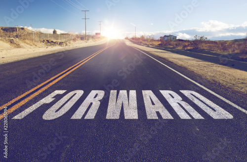 new beginnings, travel and adventure concept - close up of word forward on suburban asphalt road