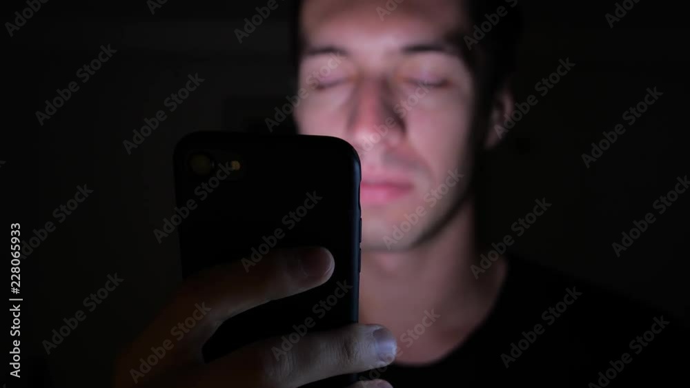 Closeup of Young Man Using Smartphone at Night, Browsing in Internet or Checking Social Networks