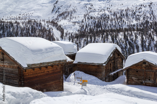 Village Eggen in winter with deep snow covered roofs in the Swiss Apls, Zermatt, Switzerland