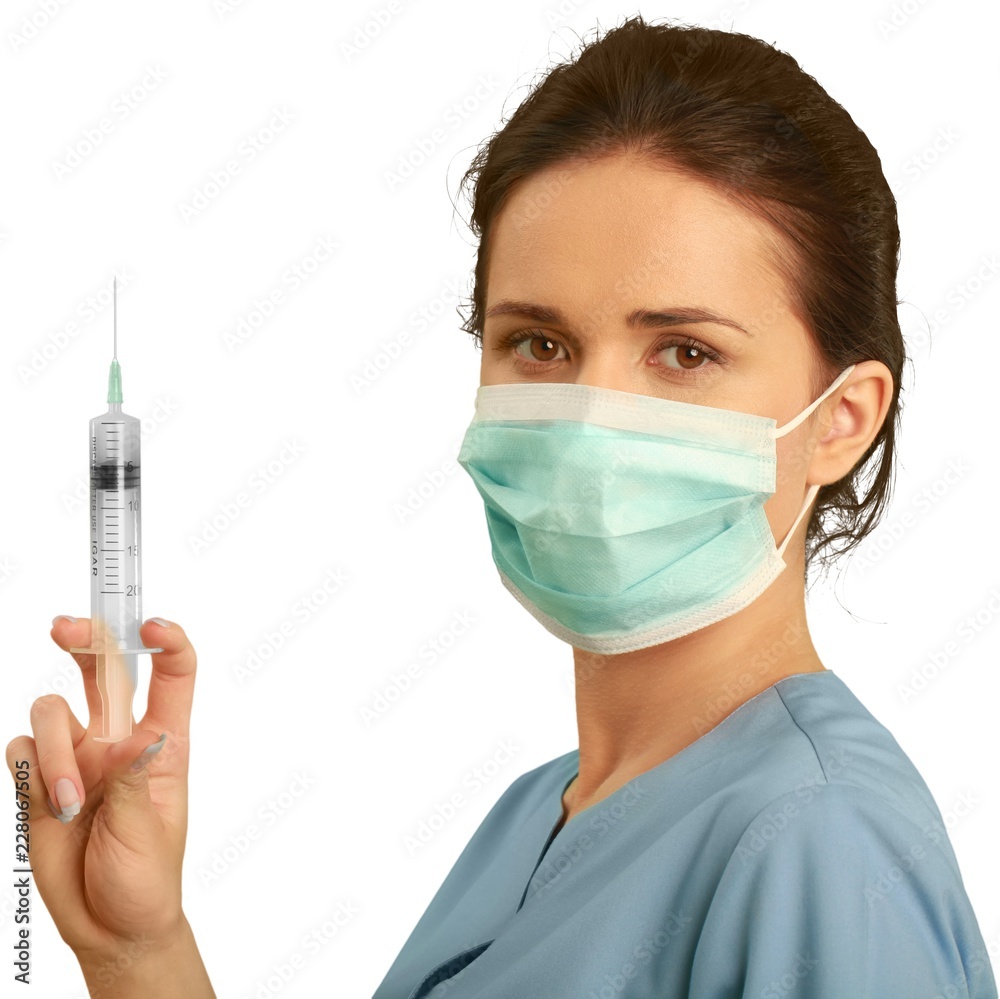 Female healthcare worker wearing a face mask and scrubs while Female healthcare worker wearing a face mask and scrubs while