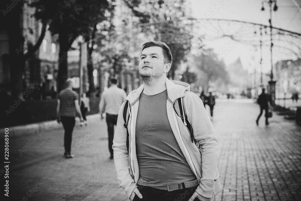Obraz premium Sad alone lonely guy at city street. Concept of loneliness among young people. Depression and stress, crisis of mans life 