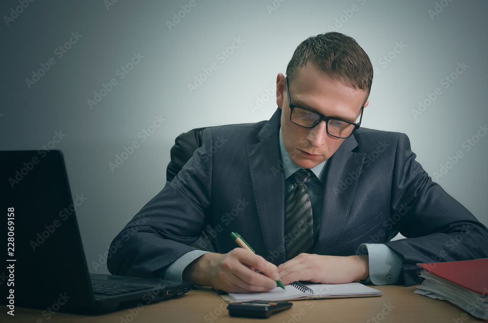 Serious businessman is working with documents and is sitting by the table. Serious businessman is working with documents and is sitting by the table.