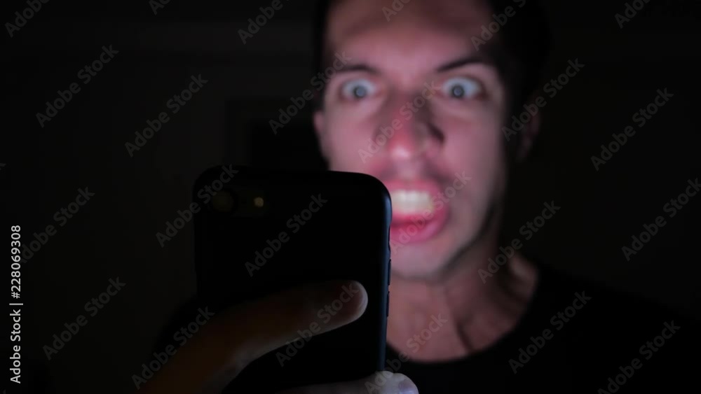 Angry Man Using Smartphone. Furious yelling man with smartphone in hand