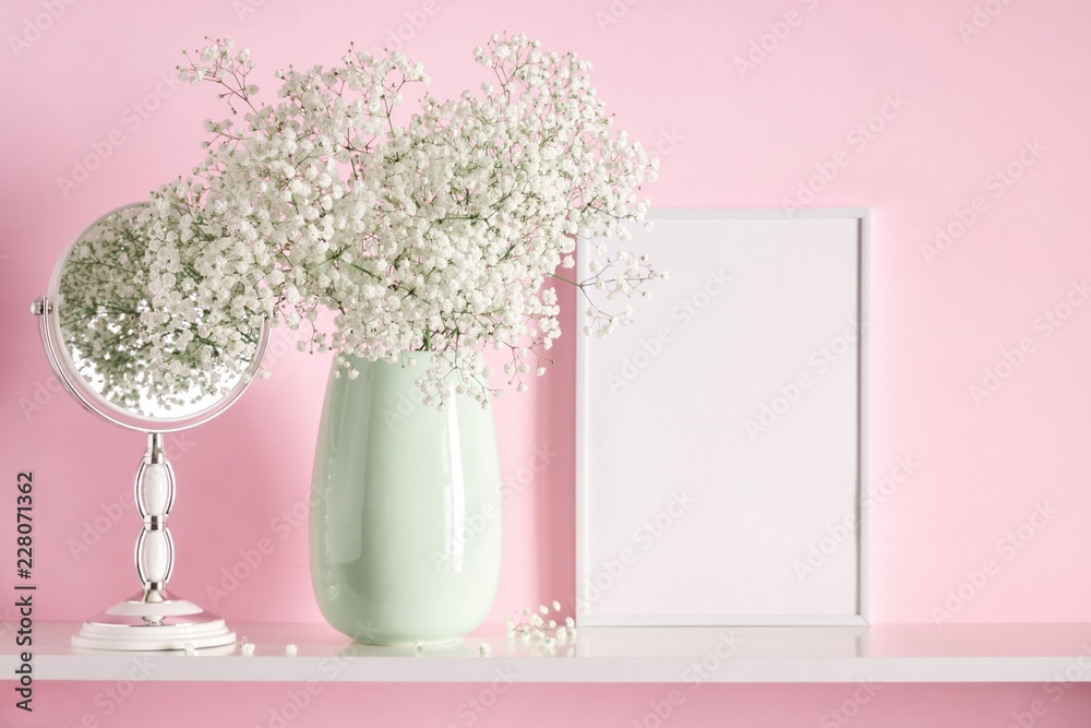 Blank mock up of photo frame on the pink background. Cosmetic table. Beautiful white flowers in a vase on a pink wall background, gift, mirror on a wooden shelf. Blank mock up of photo frame on the pink background. Cosmetic table. Beautiful white flowers in a vase on a pink wall background, gift, mirror on a wooden shelf.