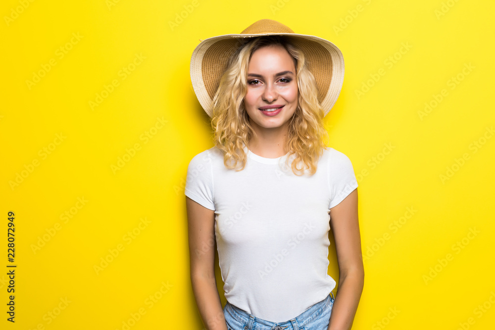Portrait of young pretty woman with short wearing straw hat on yellow background Portrait of young pretty woman with short wearing straw hat on yellow background
